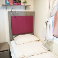 Világos, nyugodt hangulatú szoba természetes fényben vendégház szoba kétágyas elrendezésben ablak mellett